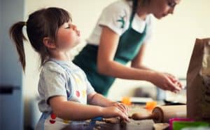 A young girl helps cook at home.