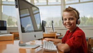 young boy on desktop computer playing waterford