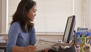 teacher looks at waterford reports at her desk