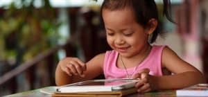 Happy child staring tablet.