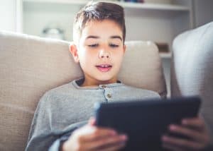 Boy using digital tablet in sofa at home