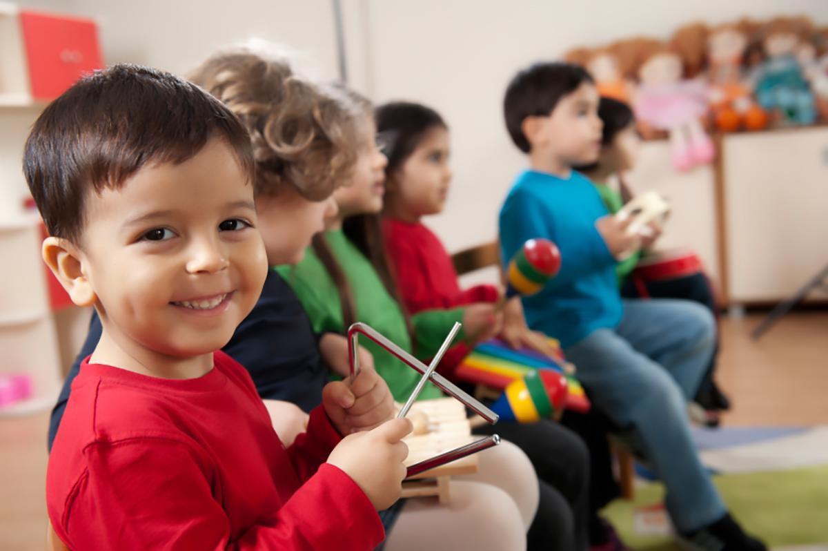 musical intelligence example of child holding triangle instrument 