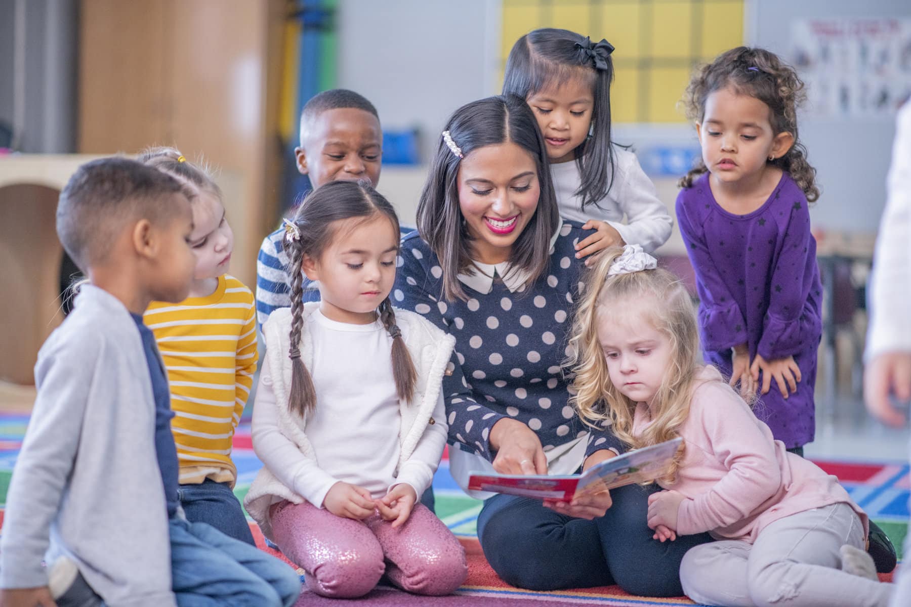 teacher reading a book to students