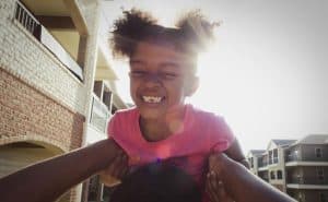 girl being held in air by parent