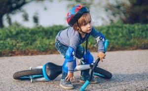Boy picking himself up after fall from bicycle