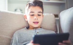 A young student reading a tablet