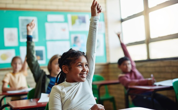 Students raising hands to take part in class discussion