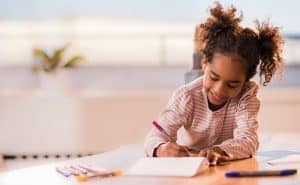 Child writing in her gratitude journal. Gratitude can help children be happier and healthier.