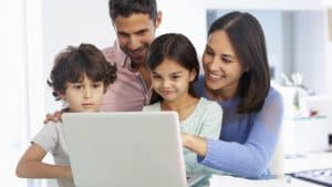 A family watching a young girl use the computer