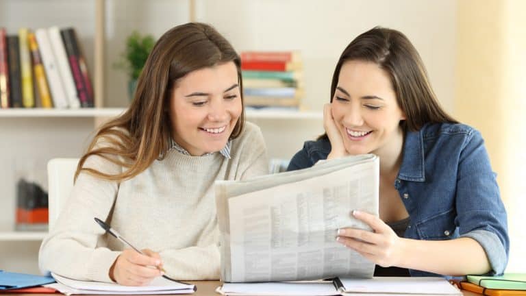Two students reading a newspaper