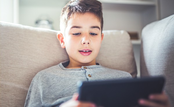 A boy reads on a tablet.