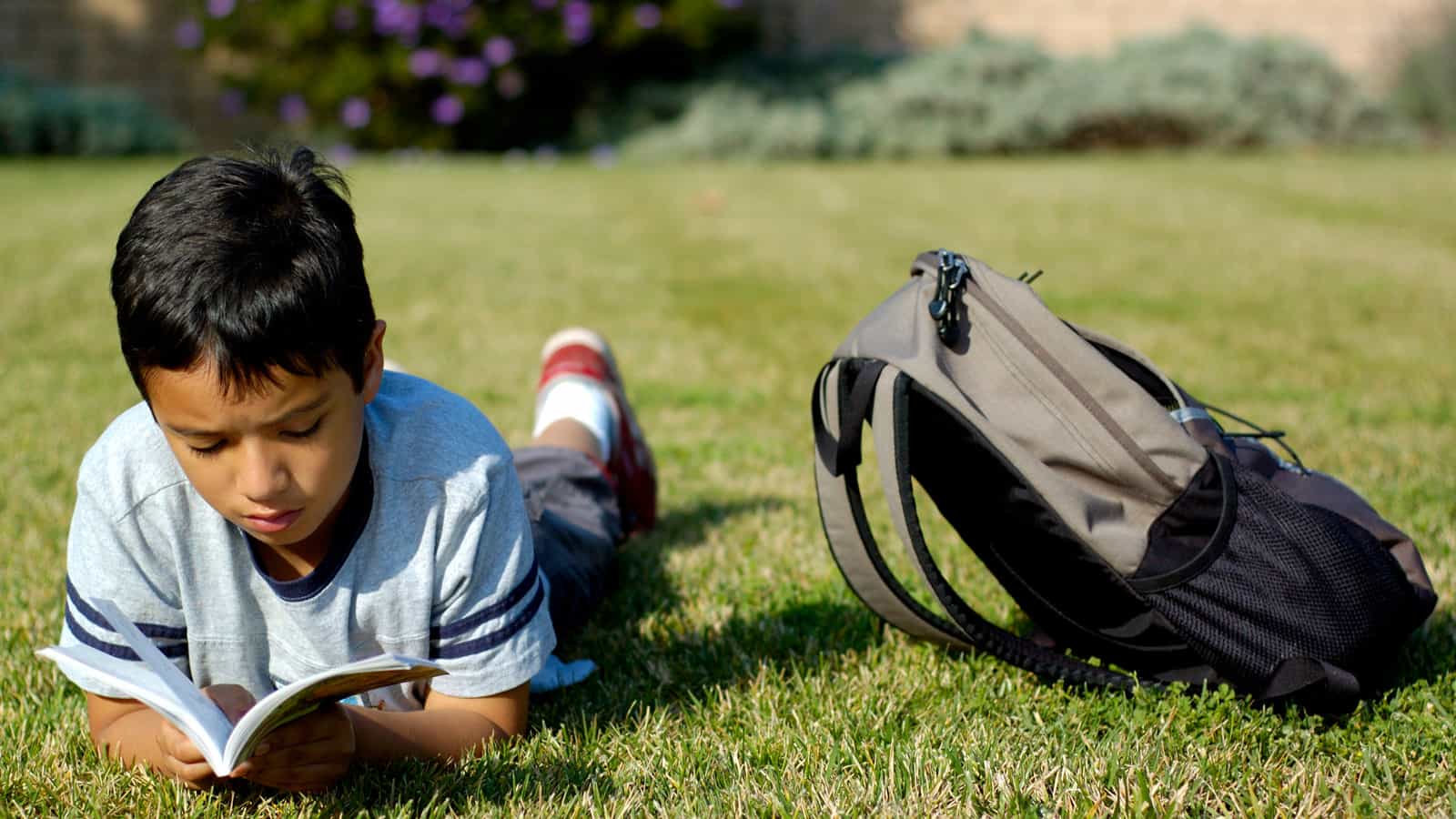 A boy reading outside. Find books about emotional and mental health perfect for family reading.