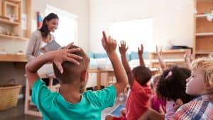Students in a classroom raise their hands. Find out what lessons we've learned about curriculum from the pandemic.