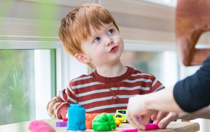 A boy works with play dough