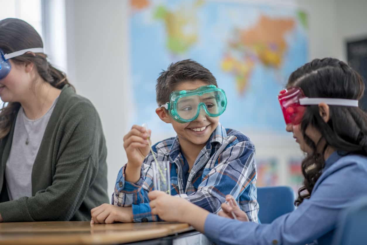 Elementary school children in class doing a chemistry experiment.