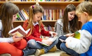 Group of students sitting on library floor and reading