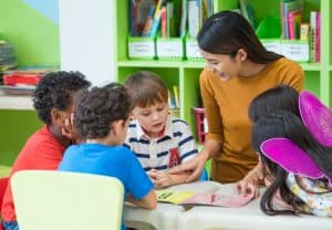 teacher reading a book to students