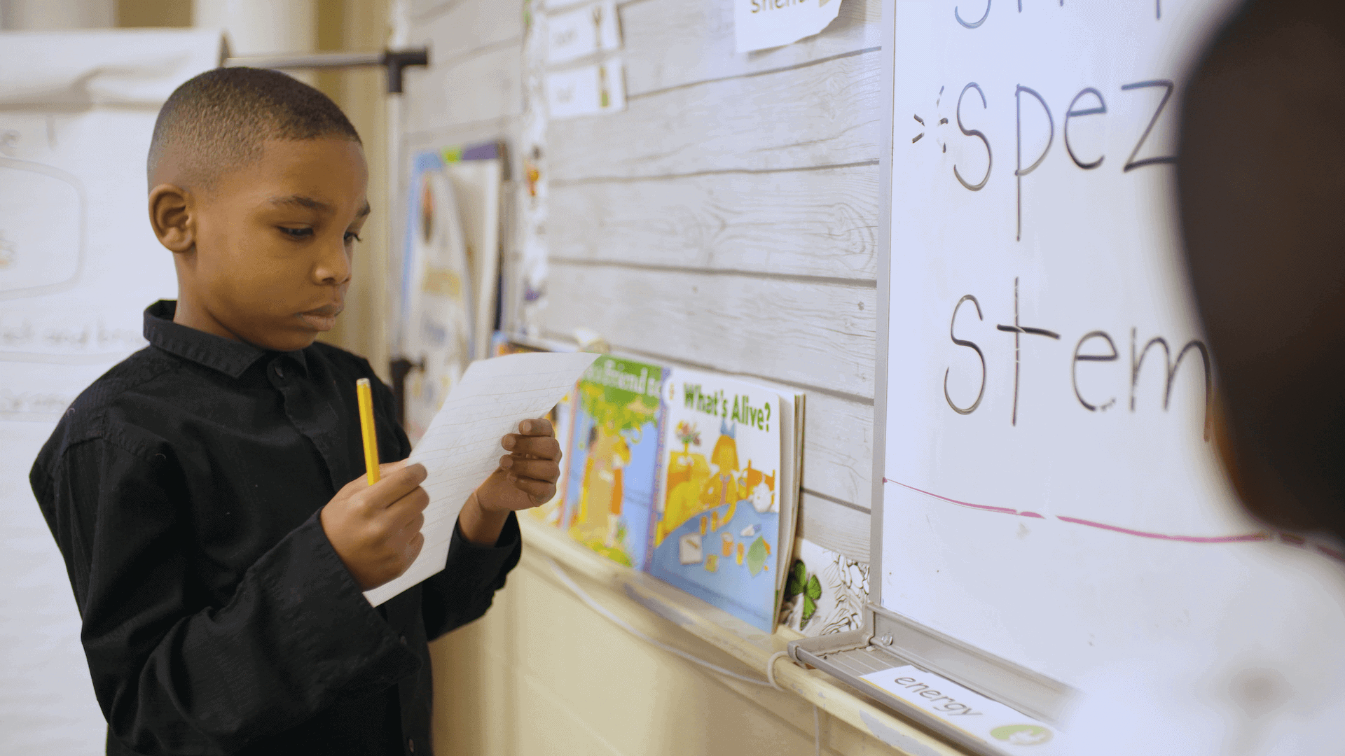 child practicing writing in classroom