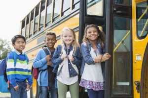 children standing by the bus