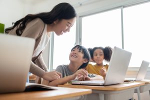 teacher helping student with online lesson