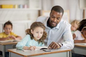 teacher helping student with online homework