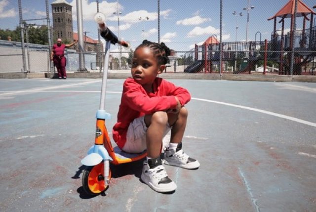 About us - Kid sitting on a scooter