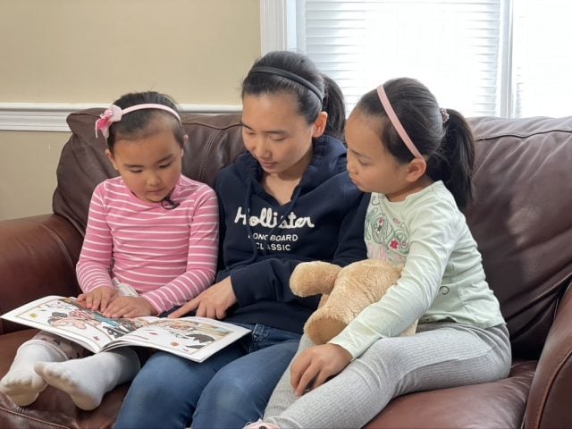Three kids reading a book